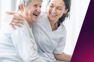 A picture of an older women with a carer in a care home