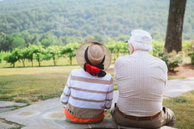 Photo by Christian Bowen on Unsplash - an older couple sitting on a stone path