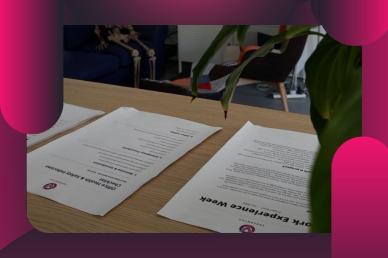 Work experience onboarding documents and a health and safety checklist laid out on a wooden office desk.