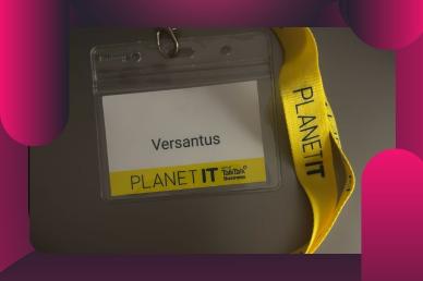 A Versantus corporate name badge on a yellow Planet IT lanyard at a cyber security event