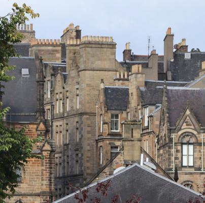 View of historic stone buildings with slate roofs and ornate architectural details
