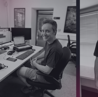 Versantus team members working at standing desks and using laptops in a collaborative office environment