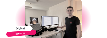 Professional Digital Services and Workspace Setup Smiling person standing at a desk setup with a laptop and monitor, showcasing a modern workspace for digital services