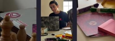 A student works on a laptop next to chess pieces and office supplies during an office work experience.